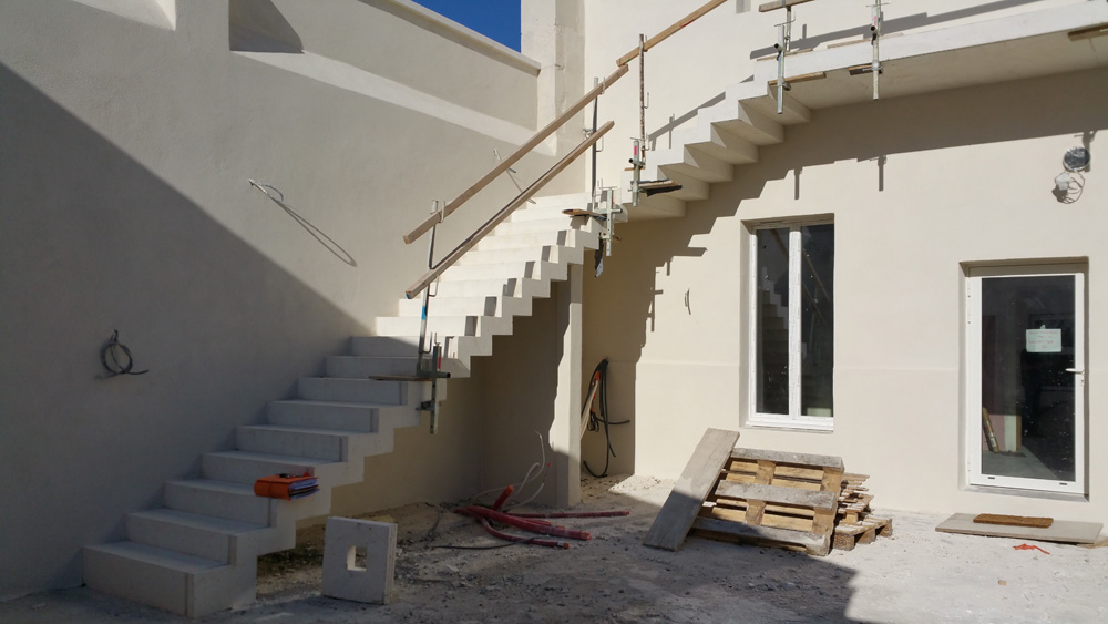 Réalisation d'un escalier en béton blanc architectonique coffré et coulé sur place pour un cabinet dentaire à Chateaurenard par Luberon Batiment.
